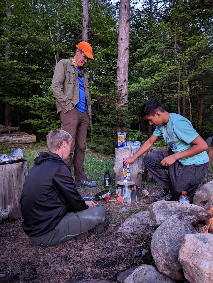 Scoutmaster supervising outdoor cooking